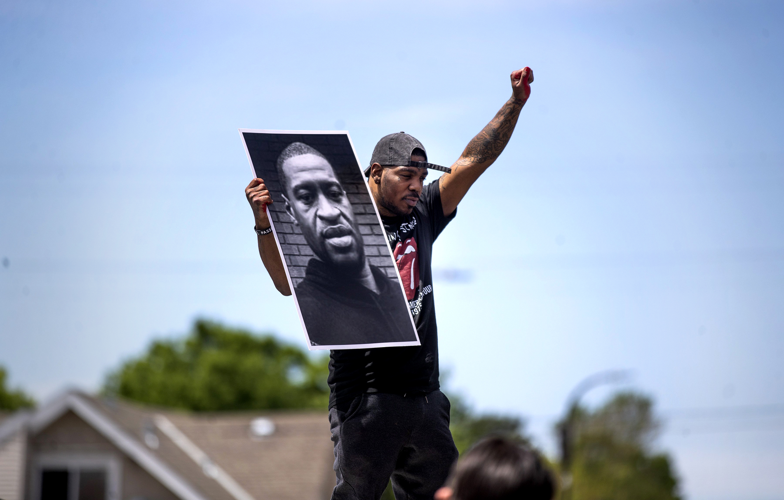 Tony L. Clark holds a photo of George Floyd outside the Cup Food convenience store, Thursday, May 28, 2020, in Minneapolis. Floyd, a handcuffed black man, died Monday in police custody near the convenience story.(Jerry Holt/Star Tribune via AP)